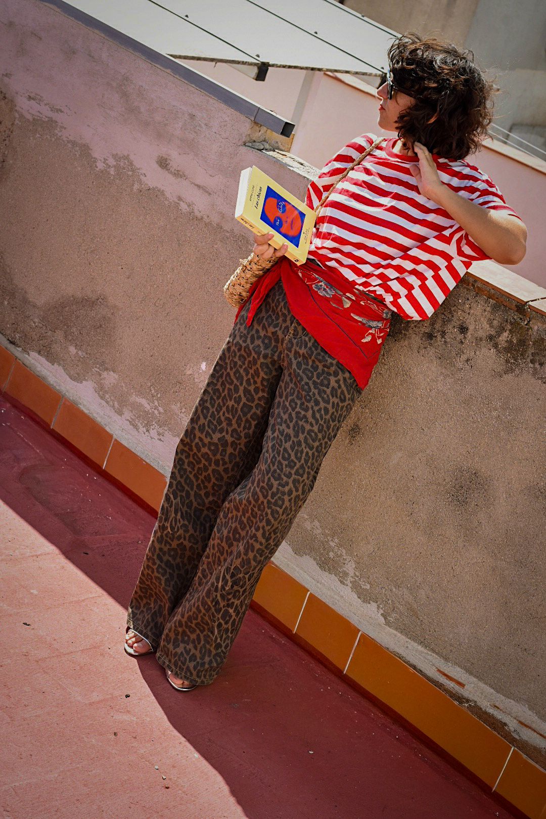 Outfit con camiseta de rayas rojas y blancas y pantalón de estampado leopardo de la marca AIIRZ de Shein, combinado con accesorios naturales y gafas de sol, en una azotea bajo luz natural