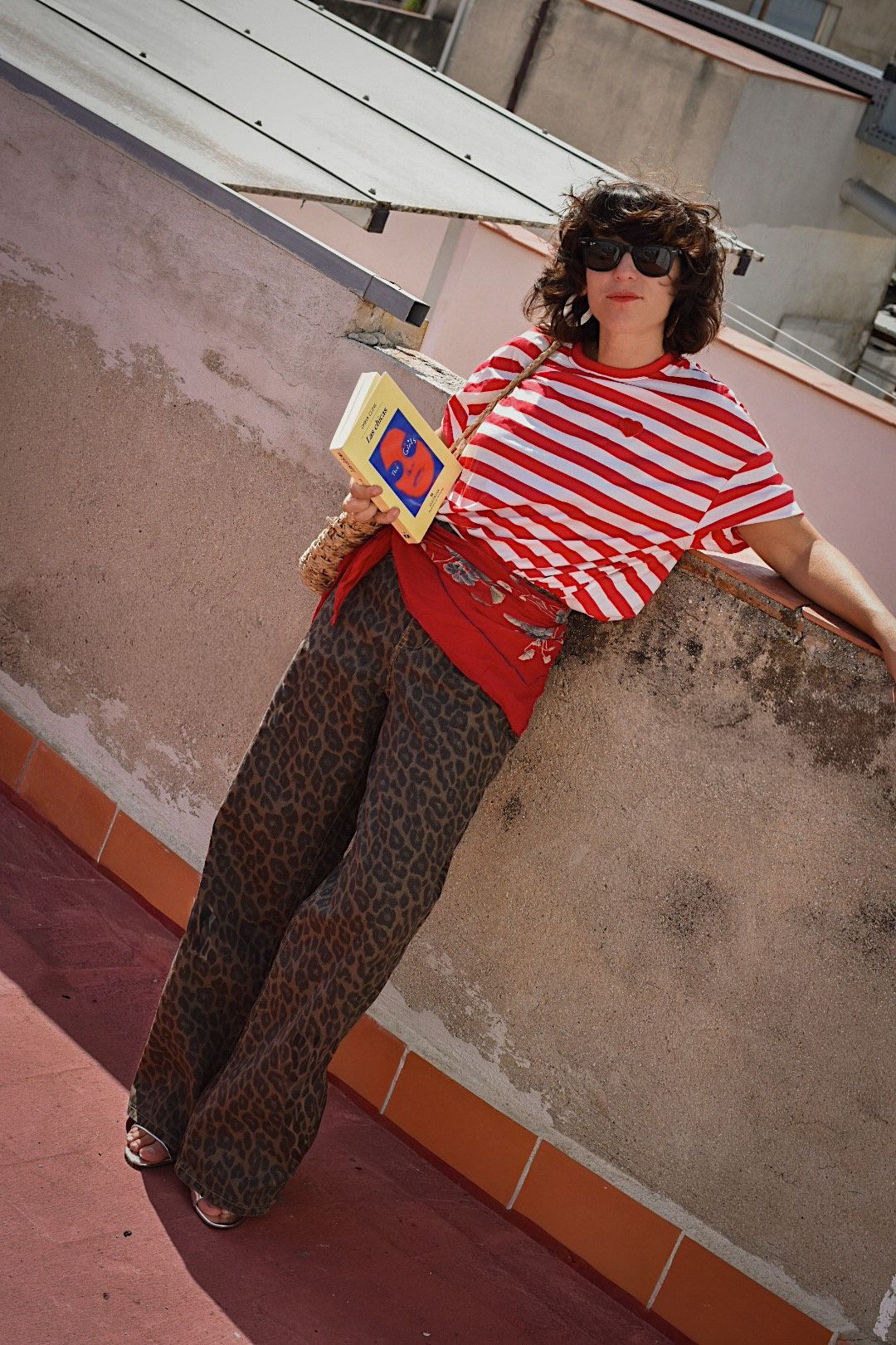 Outfit con camiseta de rayas rojas y blancas y pantalón de estampado leopardo de la marca AIIRZ de Shein, combinado con accesorios naturales y gafas de sol, en una azotea bajo luz natural.