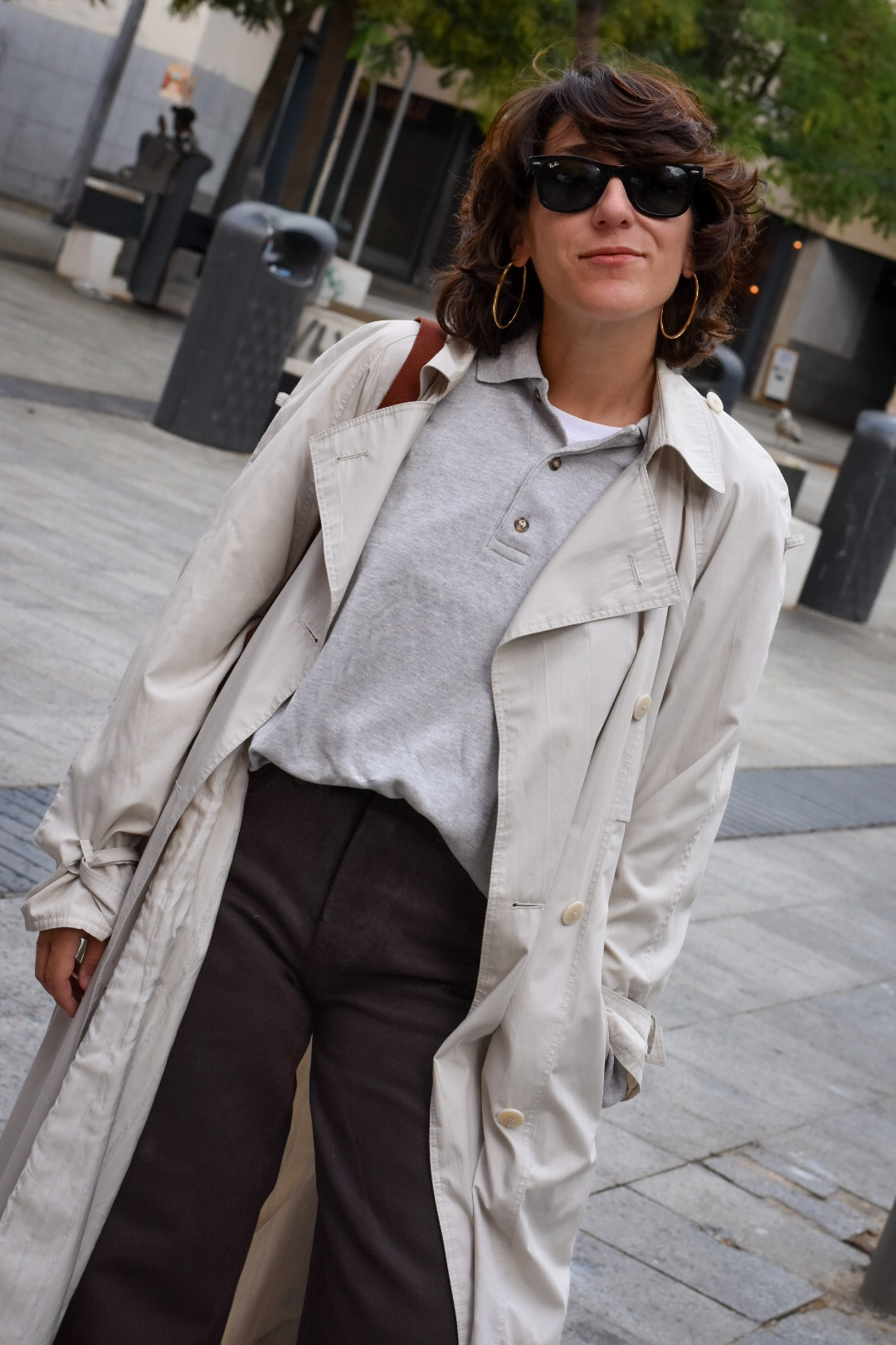 Mujer con vaquero marrón recto combinado con camiseta blanca y zapatillas, look casual de tendencia.