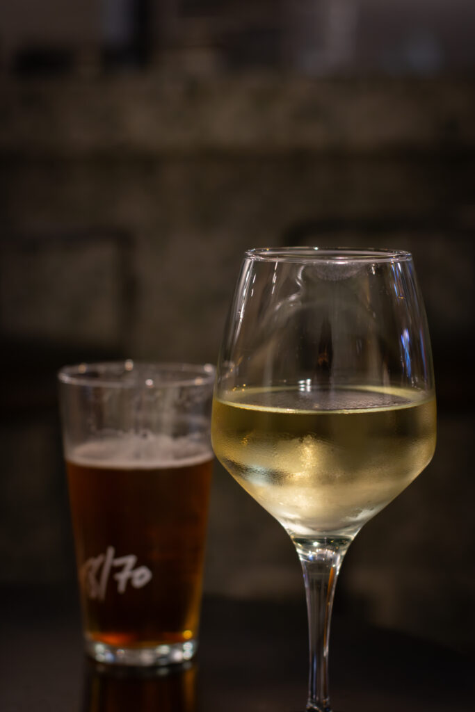 Copa de vino blanco y cerveza del restaurante Dos Manos Pita Bar del barri de Gràcia de Barcelona