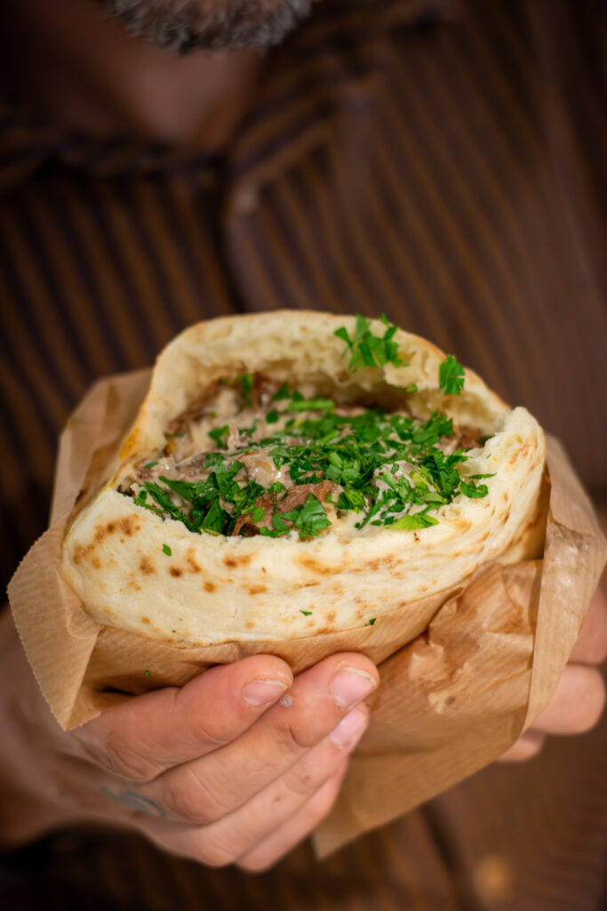 Pita All Night con carne de larga cocción, col blanca, tomate, cebolla asada, tahini y Amba de Dos Manos Pita Bar restaurante del barrio de Gràcia en Barcelona