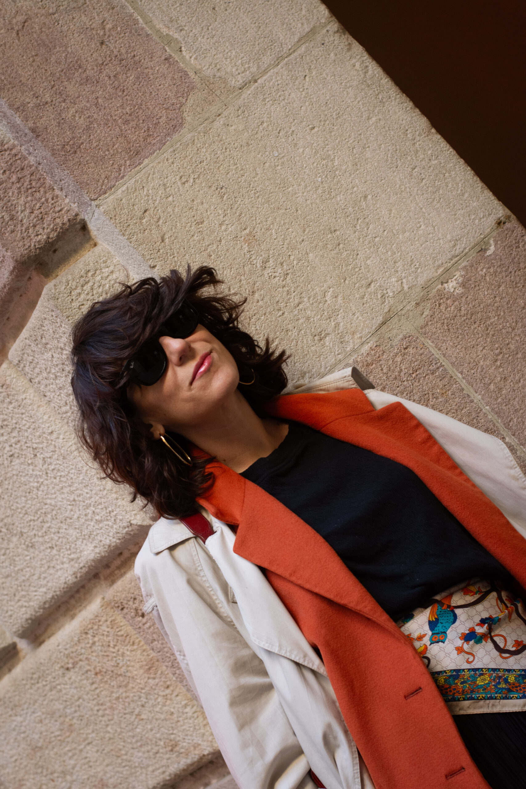 Look con gabardina y blazer de lana naranja vintage, pantalones negros arrugados, pañuelo de seda en la cintura y bailarinas Repetto Paris