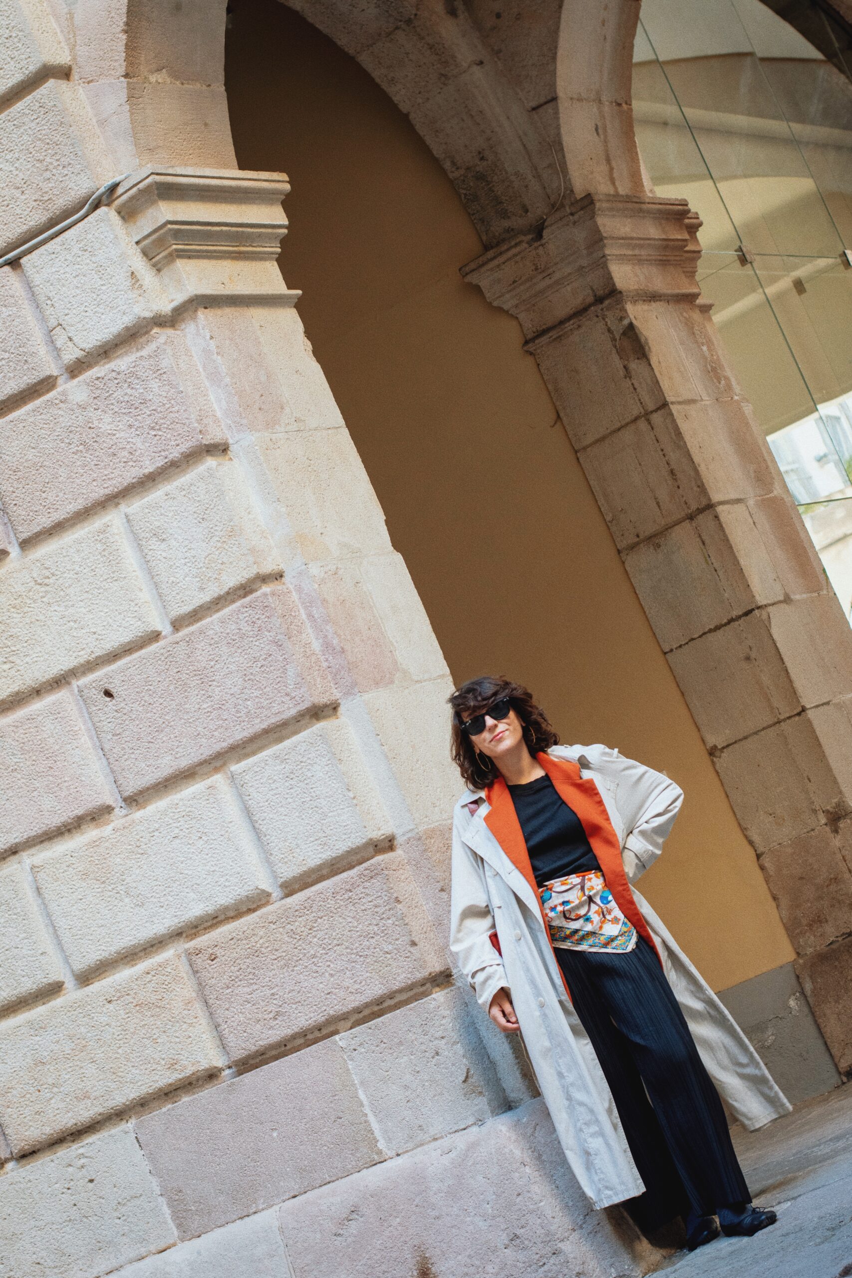 Look con gabardina y blazer de lana naranja vintage, pantalones negros arrugados, pañuelo de seda en la cintura y bailarinas Repetto Paris