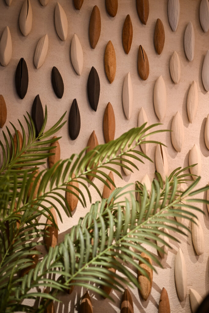 Interior de Delta Arrocería informar que incluye una pieza artística cerámica inspirada en las vainas que protegen el grano de arroz, obra de la artista Carme Balada, que aporta una dimensión sensorial y estética al acceso del restaurante.