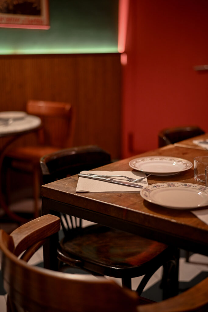 Comedor interior de Trattoria Enriquetto con cocina vista, decoración cálida y ambiente acogedor