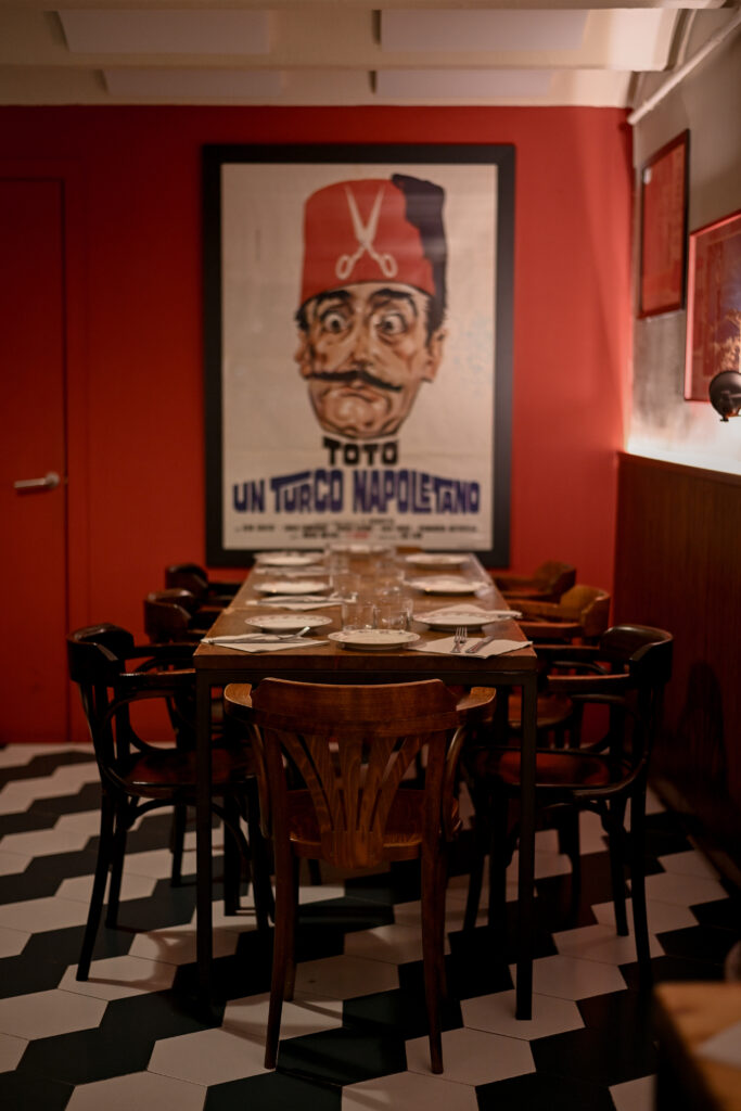 Comedor interior de Trattoria Enriquetto con cocina vista, decoración cálida y ambiente acogedor
