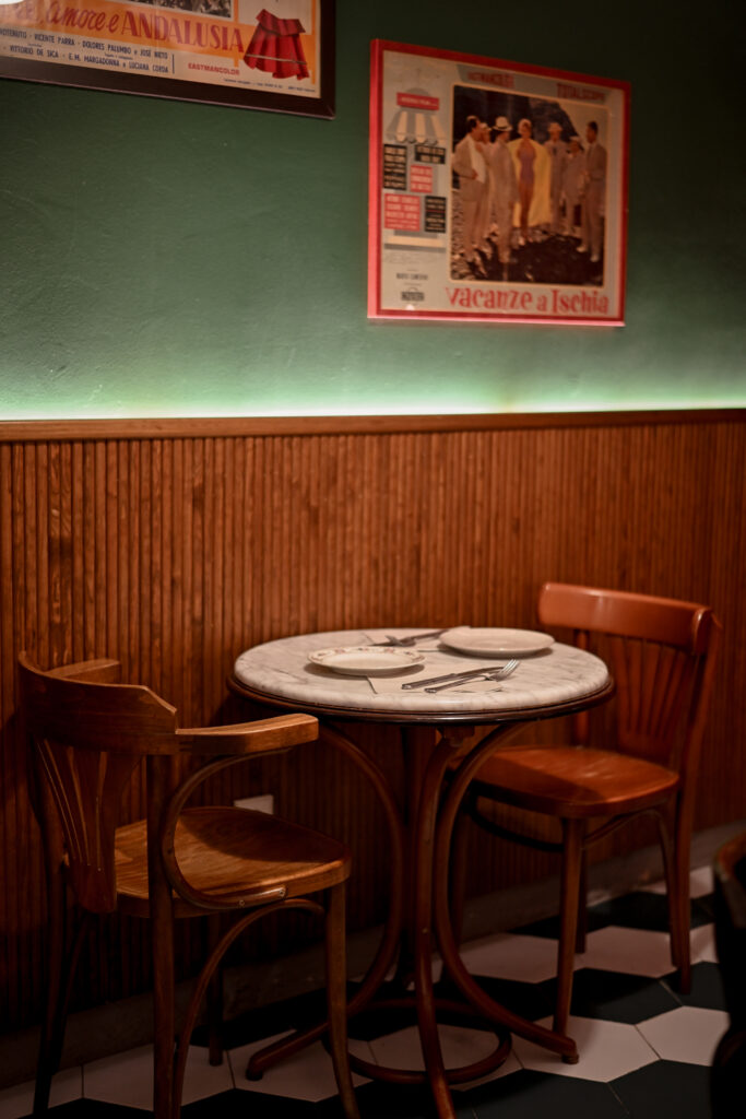 Comedor interior de Trattoria Enriquetto con cocina vista, decoración cálida y ambiente acogedor