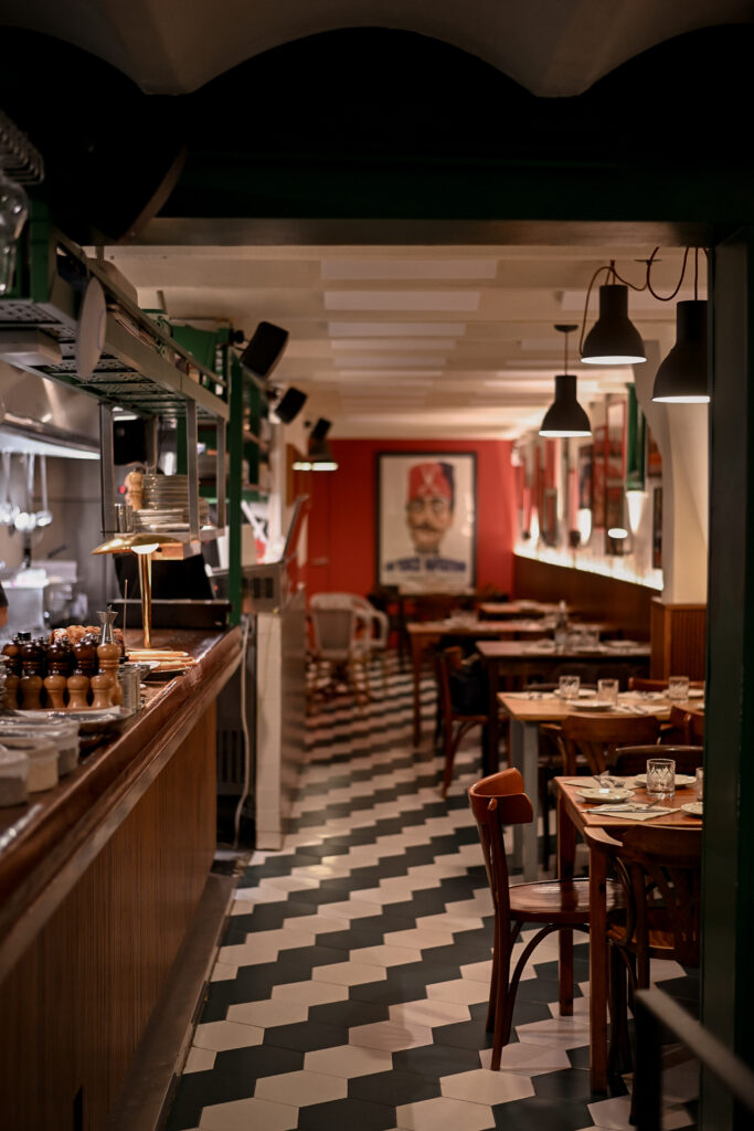 Comedor interior de Trattoria Enriquetto con cocina vista, decoración cálida y ambiente acogedor