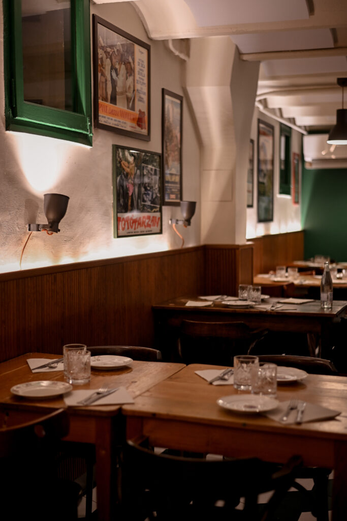 Comedor interior de Trattoria Enriquetto con cocina vista, decoración cálida y ambiente acogedor