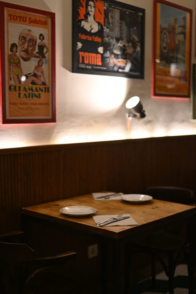 Comedor interior de Trattoria Enriquetto con cocina vista, decoración cálida y ambiente acogedor