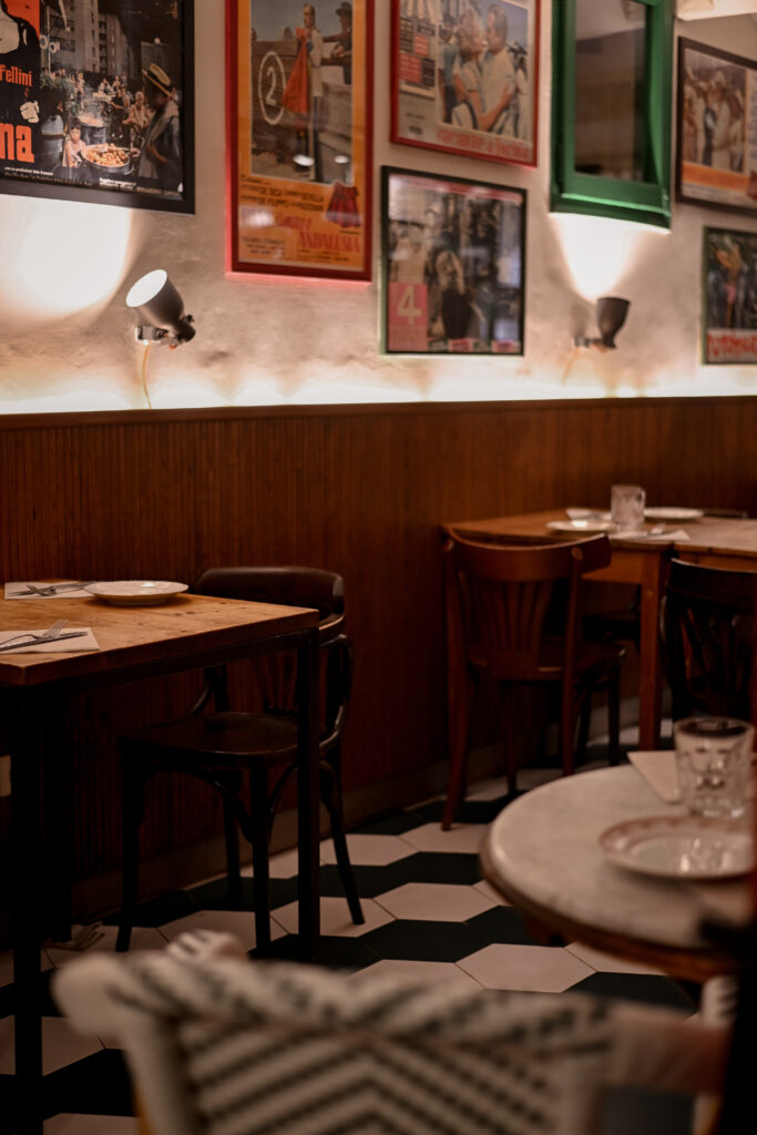 Comedor interior de Trattoria Enriquetto con cocina vista, decoración cálida y ambiente acogedor
