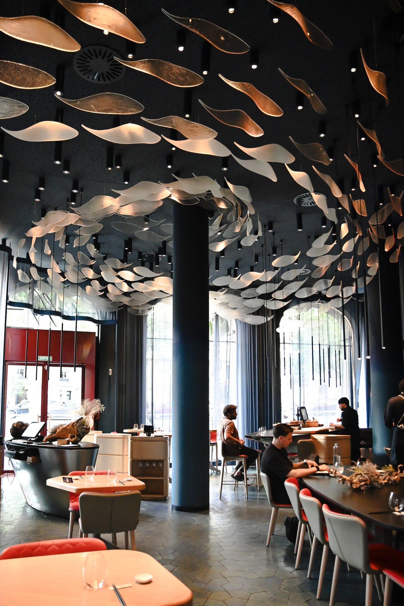 Interior Tunateca de Balfegó en la Diagonal de Barcelona con sillas rojas, cortinas azules y mesas de madera