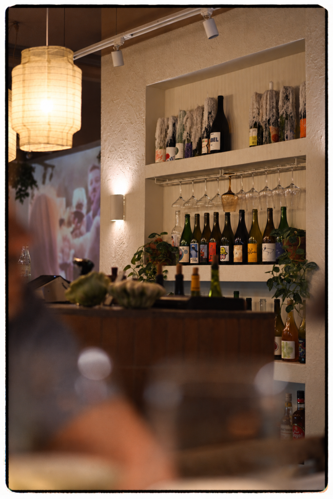 Interior restaurante Cuadro Poblenou Barcelona con botellas de vino naturales