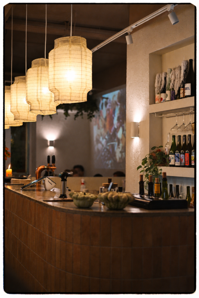 Interior restaurante Cuadro Poblenou Barcelona con botellas de vino naturales