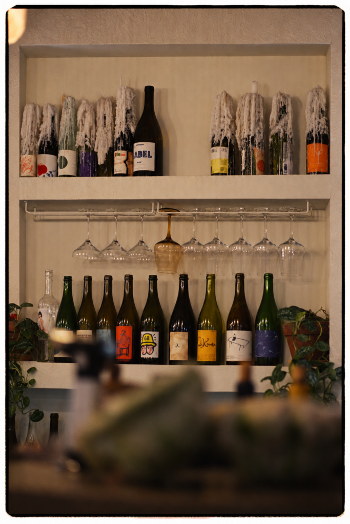Interior restaurante Cuadro Poblenou Barcelona con botellas de vino naturales